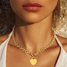 The Designer Inspired White Gold Dipped Brass Metal Heart Lock Pendant Necklace is a chic and timeless piece, featuring a heart pendant symbolizing love and protection. Available in both white gold and gold, this necklace offers versatile styling options. The pendant, measuring 0.75" X 1", hangs gracefully from an 18" chain, creating a classic silhouette. Crafted from brass and dipped in gold for a luxurious finish, this necklace is both durable and elegant. Lead and nickel compliant, it is safe Trendy Heart-shaped Gold Chain Necklace, Trendy Heart Shaped Necklace With Gold Chain, Trendy Gold Plated Heart Necklace With Heart Charm, Trendy Gold Plated Heart Charm Necklace, Valentine's Day Heart Pendant Necklace With Gold Chain, Trendy Heart-shaped Gold Plated Necklaces, Heart-shaped Gold Chain Necklace For Gift, Heart Shaped Gold Chain Necklace For Gift, Trendy Gold Heart Charm Necklaces