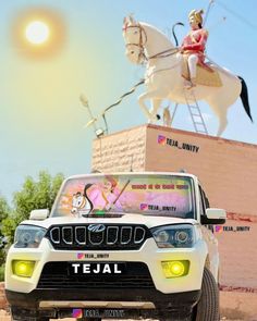 a jeep is parked in front of a statue of a woman on a white horse