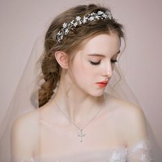 a woman wearing a bridal headpiece with flowers on it