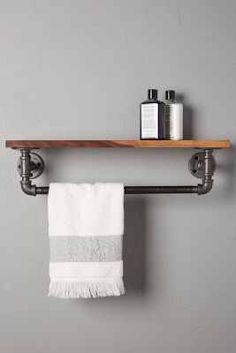 a towel rack with two towels hanging from it's sides and a wooden shelf above it