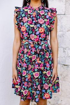 This bold dress is stunning! It's going to look so fabulous this spring and summer! This dress may have a black background but it doesn't make it any less perfect for the season! Those vibrantly colors flowers truly pop against it! This dress is going to look amazing with heels, sneakers, or sandals! Round neckline Button keyhole back Ruffled cap sleeves Tied waist Vibrant floral print No stretch Cindy is wearing the small. Bold Dress, Bold Dresses, Heels Sneakers, Black Floral Dress, Mint Julep Boutique, Floral Dress Black, High Neckline, Black Floral, Black Background