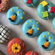 there are many decorated donuts on the table with stars and sunflowers painted on them