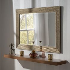 a mirror and some candles on a shelf