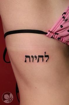 a woman's stomach with the word hebrew tattooed on it