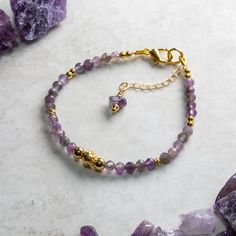 Elegant Amethyst and gold bracelet hand crafted with care and attention to detail using AA 4mm faceted Amethyst beads, gold fill accent beads and a gold plated simulated twisted wire central bead. The bracelet is constructed using quality 19 strand nylon coated beading wire which is both flexible for a comfortable wear and extremely durable. The bracelet measures 17.5cm and is fastened with a gold plated lobster claw clasp and a 30mm extension chain for an adjustable fit up to 20 cm. Amethyst is Elegant Gold Crystal Bracelet For Meditation, Gold Charm Bracelet With Natural Stones Gift, Spiritual Charm Bracelet With Faceted Beads As A Gift, Spiritual Gold Charm Bracelet With Gemstones, Spiritual Gold Gemstone Charm Bracelet, Spiritual Amethyst Jewelry With Lobster Clasp, Spiritual Amethyst Gold Bracelets, Faceted Amethyst Beaded Bracelets As A Gift, Gold Amethyst Beaded Bracelets For Jewelry Making