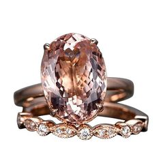 an engagement ring and wedding band set with a large pink diamond in the center, on top of a rock