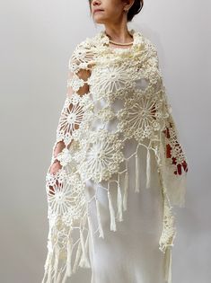 a woman wearing a white crochet shawl