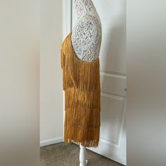 a mannequin is dressed up with a lace top and tasselled skirt