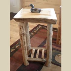 a small wooden table with a duck figurine on top