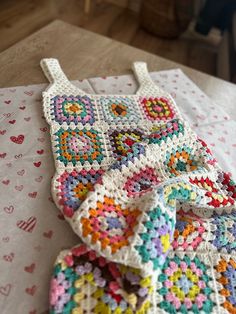 a crocheted blanket is laying on a table