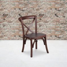 a wooden chair sitting in front of a brick wall