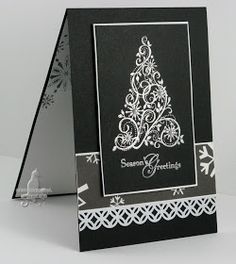 a black and white card with a christmas tree on the front, snowflakes in the back