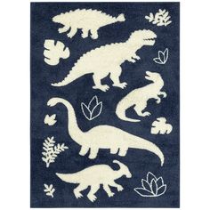 a blue rug with white dinosaurs and leaves on the ground, in front of a black background