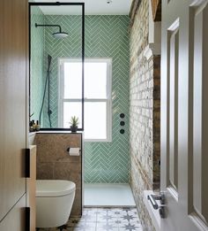 a bathroom with green and white tiles on the walls