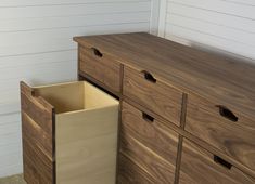 a wooden dresser next to a white wall