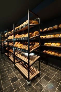 a bakery filled with lots of different types of breads and pastries on shelves