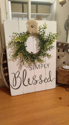 a wooden sign that says simply blissed with a wreath on it