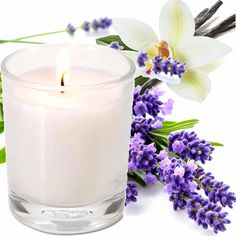 a white candle sitting next to some purple flowers