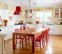 a kitchen filled with lots of red chairs next to a wooden table and counter top