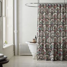 a bathroom with a bathtub, shower curtain and rug