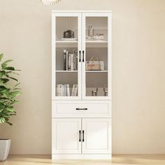 This tall bookcase with 4 doors is a modern style, it uses a light white finish to show elegant charm. It matches well with various decors. This glass door cabinet features 1 middle drawer and 4 cabinets with doors. The upper cabinet features glass doors and 3 shelves, keeping your favorite items in sight. You can use the cabinet with more peace of mind. This floor cabinet is a wonderful combination of simple design and modern charm, which makes it an elegant addition to your home. Wade Logan® | Glass Door Cabinet, White Pantry, 3 Shelf Bookcase, Storage Bookcase, Bookcase With Glass Doors, Display Bookcase, Tall Bookcase, Pantry Storage Cabinet, Kitchen Pantry Storage