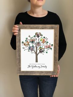 a woman holding up a framed family tree