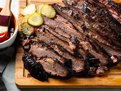 sliced steak with sauce and vegetables on cutting board next to bowl of ketchup