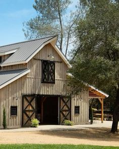 a large barn with a metal roof and windows