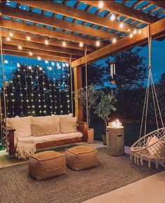 an outdoor living room with lights strung from the ceiling