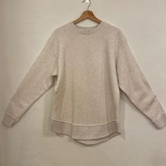 L.A.T Crewneck Cream Color Curved Hem Longer Length Relaxed Long Sleeve Tops For Casual Gatherings, Relaxed Fit Knit Top With Ribbed Cuffs For Layering, Cozy Relaxed Fit Knit Top For Layering, Relaxed Crew Neck Tops For Layering, Relaxed Crew Neck Top For Casual Gatherings, Fall Crew Neck Tops For Casual Gatherings, Casual Crew Neck Knit Top For Layering, Cream Relaxed Fit Crew Neck Knit Top, Oversized Crew Neck Knit Top