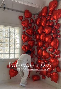 a man standing in front of a red heart wall