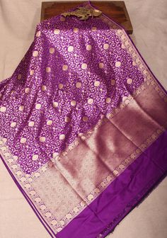 The Purple Pure Banarasi Katan Silk Saree is a stunning embodiment of elegance, featuring a delicate fLotus jaal that weaves a story of artistry and tradition. The rich purple hue adds a regal touch, while the grand pallu showcases intricate designs that enhance its luxurious appeal.  Crafted from silk, this saree drapes beautifully, making it an ideal choice for festive occasions and celebrations, where timeless beauty meets exquisite craftsmanship. SILK MARK CERTIFIED This saree is ready to wear with fall and pico done. Handmade silk tassels adorn the pallu and add more grace to it. An unstitched blouse fabric is included. *Note: There may be minor variations in the shade, the texture of the product. Hues/textures show differently due to variations in screen settings and other factors. * Saree Drapes, Banarasi Katan Silk Saree, Katan Silk Saree, Rich Purple, Katan Silk, Purple Hues, Intricate Designs, Blouse Fabric, The Purple