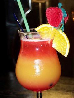 a drink with orange and red garnish in it on top of a table