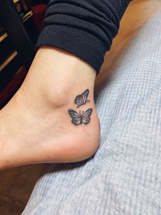 a woman's foot with a small butterfly tattoo on her left ankle and right leg