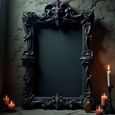 an ornate black frame with candles in front of it on a table next to a brick wall