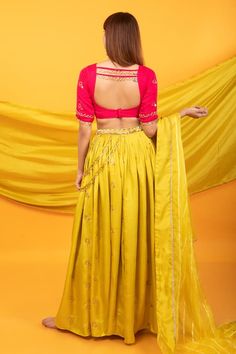 Canary yellow kalidar lehenga with intricate handwork floral buttis and side tassels. Comes with contrast pink blouse with floral buttis and tassels and a semi-sheer yellow dupatta.
Components: 3
Pattern: Embroidered
Type Of Work: Floral Buttis
Neckline: Scoop
Sleeve Type: Elbow
Fabric: Silk Blend
Color: Yellow
Other Details: 
Lehenga:
Floral buttis
Side tassels
Attached lining
Length: 43 inches
Closure: Side zip
Blouse:
Back cutout
Back straps
Tassels
Closure: Back hooks
Dupatta:
Semi-sheer
Linear patterns
Product weight (in kgs): 1.5
Occasion: Mehendi and Haldi - Aza Fashions Designer Yellow Kundan Sets, Yellow Chanderi Choli With Traditional Drape, Traditional Drape Yellow Chanderi Choli, Designer Yellow Chanderi Choli, Yellow Chanderi Traditional Wear For Reception, Yellow Pre-draped Saree With Resham Embroidery For Navratri, Yellow Pre-draped Saree With Dupatta For Reception, Yellow Pre-draped Saree For Diwali Reception, Bollywood Style Yellow Kundan Set