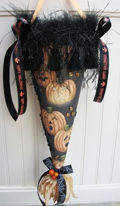 an umbrella decorated with pumpkins and feathers hanging from a hook on a door handle