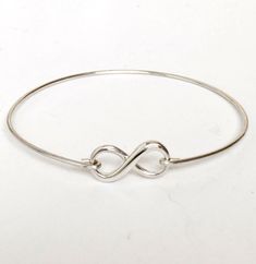 "This is a small sized dainty & delicate sterling infinity which I transform into an infinity bangle bracelet with sterling silver bangle band. PURITY OF METAL: This makes a great gift for teen girls since all elements of the bracelet are sterling silver. Sterling silver is suggested for teen girl jewelry because of the purity of the metal. It's great for adults too. PERSONALIZED OPTIONS: Select optional initial charms (up to 3) to dangle from the infinity loop. I can also add charms to the Hypoallergenic Sterling Silver Bangle Bracelet Gift, Dainty Sterling Silver Bangle, Simple Silver Bangle Jewelry, Everyday Nickel-free Infinity Jewelry, Simple Adjustable Bangle As A Gift, Adjustable Sterling Silver Bracelet With Lobster Clasp As Gift, Minimalist Infinity Bracelets For Gifts, Minimalist Infinity Bracelet For Gift, Sterling Silver Infinity Bracelets For Anniversary