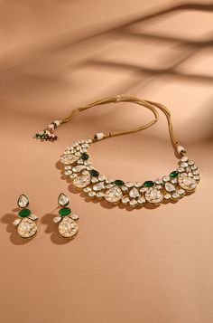 Exude timeless charm with this classic and elegant kundan set, adorned with captivating emerald stones and finished in gold-plated metal. Perfect for adding a touch of sophistication to any ensemble, this set is a timeless addition to your collection. Finish: 22KT Gold Plating Material: Brass, Kundan, Emerald Color: Gold, White & Green Size: Free Size, Adjustable Closure Type: Draw String Box Contains: 1 Necklace, 1 Pair Earrings Festive Emerald Jewelry Sets, Gold-plated Green Kundan Necklace With Meenakari, Green Kundan Necklace With Meenakari In Gold Plated, Green Kundan Necklace For Formal Occasions, Green Kundan Necklace With Meenakari Detail, Formal Green Kundan Necklace, Formal Gold Kundan Necklace With Emerald, Green Kundan Necklace With 17 Jewels, Gold Emerald Jewelry Sets For Celebration