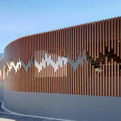 an artisticly designed building with wooden slats on the outside wall and side walls