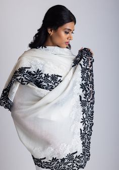 Elevate your style with this classic ivory cashmere scarf, featuring a striking black leaf embroidery border that brings in a bold contrast and an understated sophistication. The delicately handcrafted ivory floral lace inset enhances the design's elegance, creating a seamless blend of intricate detailing and refined beauty. Soft, warm, and versatile, this luxurious scarf is perfect for any occasion, effortlessly complementing both casual and formal outfits. Wrap yourself in this timeless piece Luxury Festive Pashmina Shawl With Intricate Embroidery, Luxury Elegant Pashmina Shawl With Embroidered Border, Luxury Embroidered Shawl Scarf, Luxury White Traditional Pashmina Shawl, Luxury Traditional Scarves With Intricate Embroidery, Embroidery Border, Black Leaves, Formal Outfits, Lace Inset