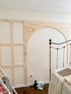 a bedroom with white walls and wood trim around the headboard is being worked on