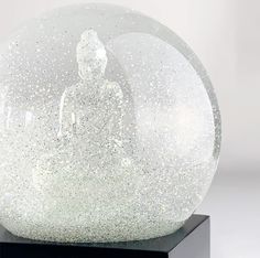 a snow globe sitting on top of a black stand