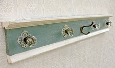 an old coat rack with knobs and handles on the wall in front of a white wall