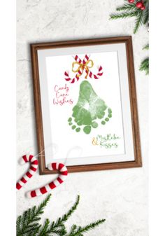 a christmas card with candy canes on the side and an image of a handprint