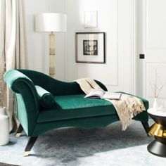 a green chair sitting on top of a rug in a living room next to a lamp