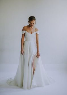 a woman in a white wedding dress posing for the camera