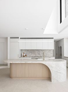 a large kitchen with an island and marble counter tops in the middle of the room