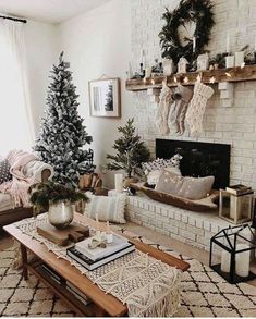 a living room decorated for christmas with white brick fireplace and tree in the corner,