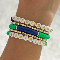 the bracelets are decorated with different colored beads and beaded letters that spell out words